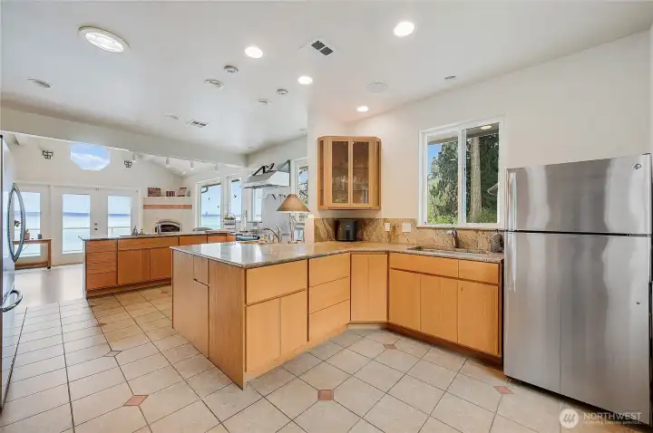Enter through the chefs kitchen. Three sinks and inch thick stone countertops compliment the tile floors and custom cabinetry. The owner of this home was a woodworker, and it shows.