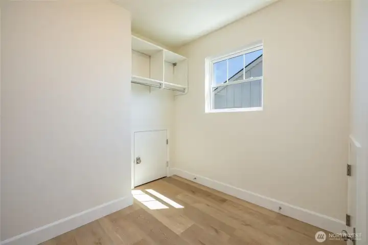 Master closet with shelving and window