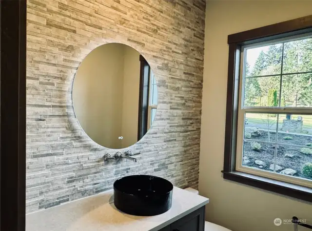 Powder room features stone wall & backlit mirror