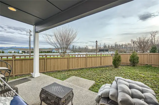 Covered backyard patio with fully fenced backyard.