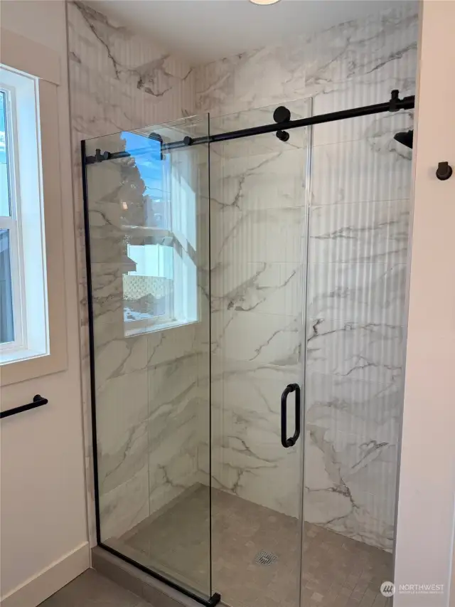 Primary bath shower with sliding glass door.