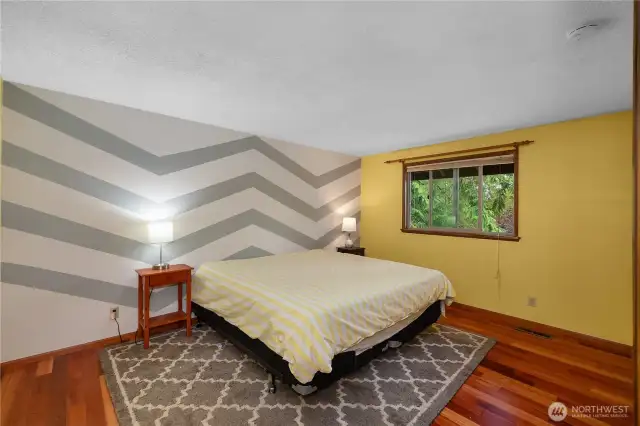 2nd BR with chevron accent wall and more wood floors.