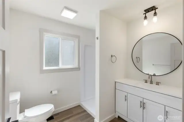 Primary bathroom with all new fixtures, cabinets and shower. Carefree living in a home that is new from the studs out!