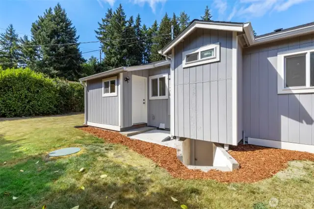 Rear of home with access to crawlspace/ furnace and hotwater tank.