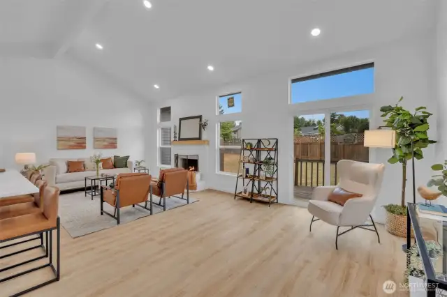 The living room's vaulted ceilings and strategic window placement create an airy, light-filled space with seamless access to the backyard.