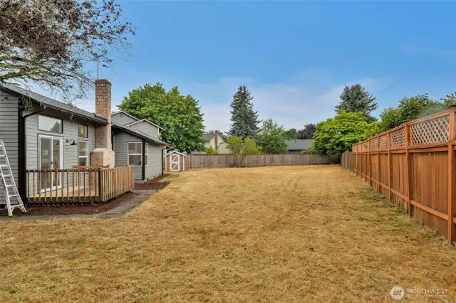 The spacious backyard extends from the deck, offering a blank canvas for your landscaping dreams with complete privacy fencing throughout.