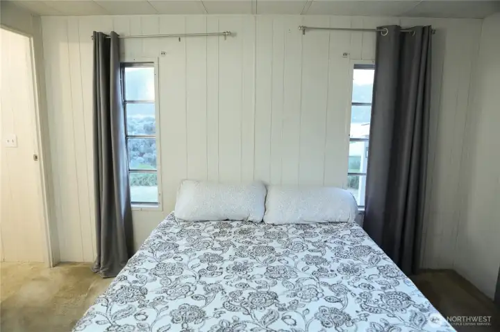The main bedroom boasts stunning views of Lake Chelan, carpeting, and a spacious private ensuite for ultimate comfort and privacy.