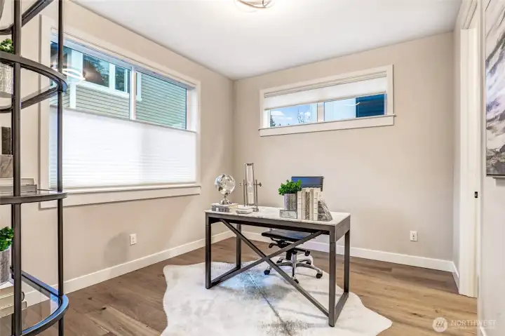 Main-level flex room just around the corner from the kitchen — perfect as a second home office, homework space, or playroom. Generous natural light and a clean, modern design make it easy to tailor to your needs.