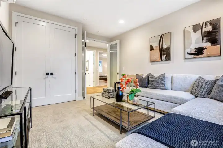 Media room with great flow to the upper level bedrooms, featuring double-door storage, glass front French doors, and ample wall space for an oversized TV or artwork.