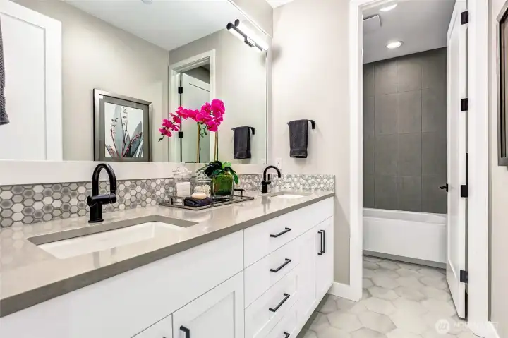 Stylish upstairs hallway bath with dual sinks, abundant storage, and a separate tub/shower room. Perfectly designed to serve two secondary bedrooms and the bonus room with ease.