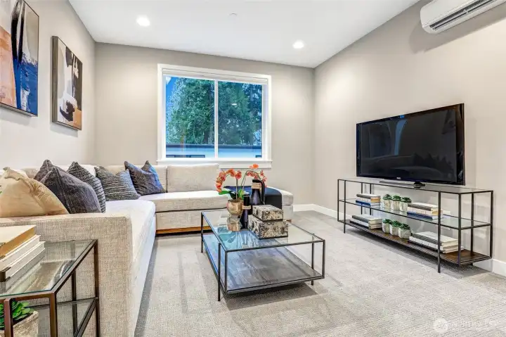 Spacious second-level media room with room for a large sectional, full-wall TV, and gaming or lounge furniture. A perfect flex space for movie nights or casual hangouts.