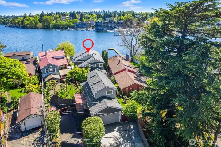 Aerial view of the property. Detached 4-car tandem garage with studio built above the garage. The home is perfectly positioned in front of the garage at the waterfront.