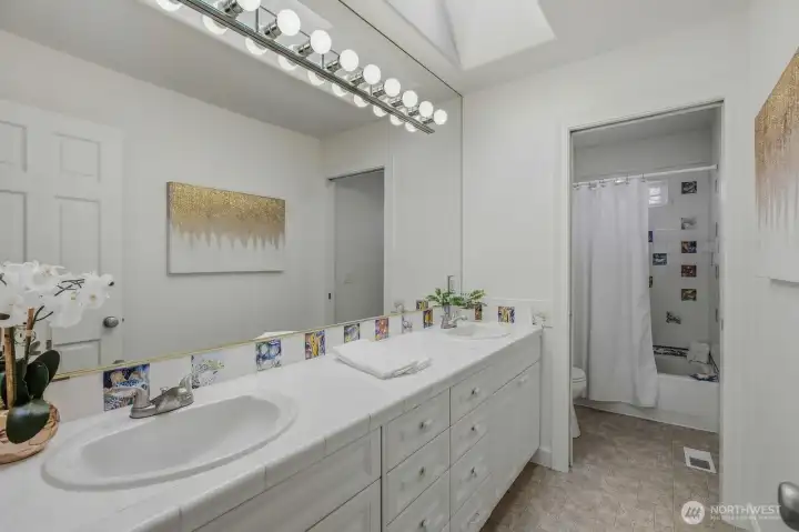Full bathroom with double vanities.