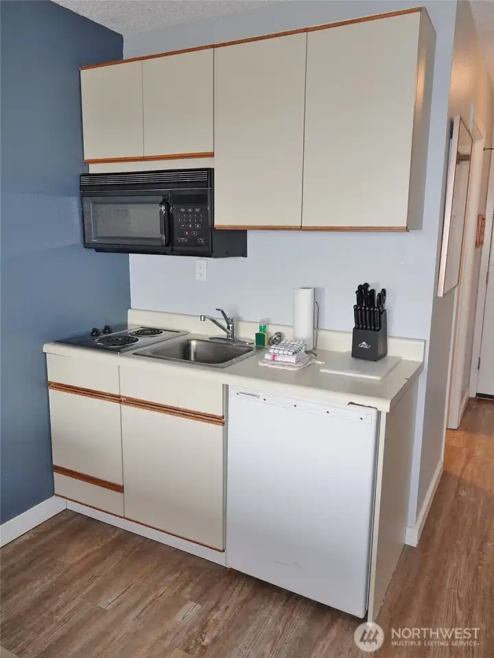 Kitchenette w/ mini-frig, 2-burner stovetop, microwave, sink.