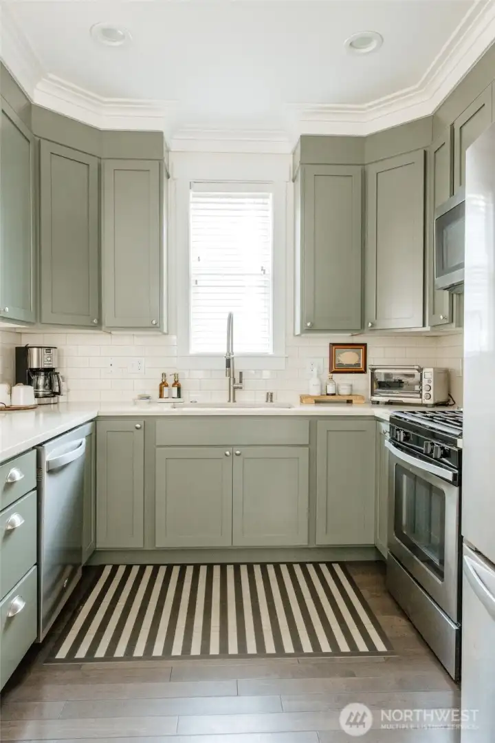 It's well appointed with charming green cabinets and quartz countertops.