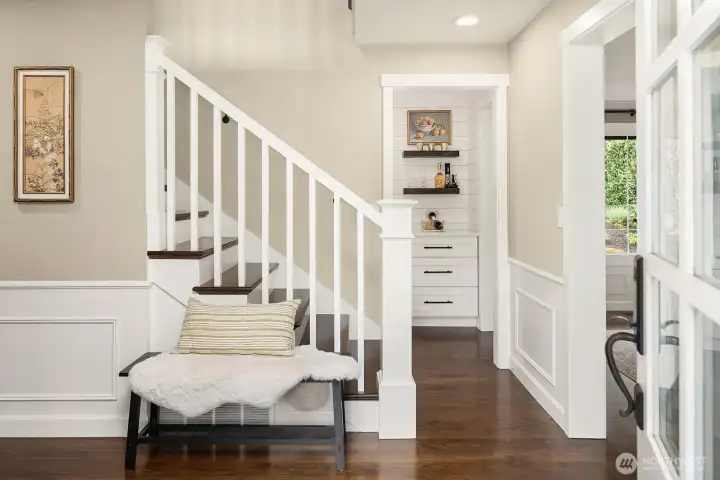 Rich hardwood floors and elegant wainscoting set a warm, sophisticated tone the moment you step inside, with a beautifully crafted staircase and abundant natural light making an unforgettable first impression.
