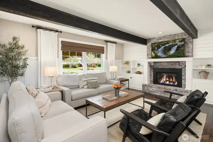The inviting living area centers around a stunning new fireplace insert framed by built-ins, with exposed beamed ceilings and oversized windows that bathe the space in the natural light this east-west oriented home is known for.
