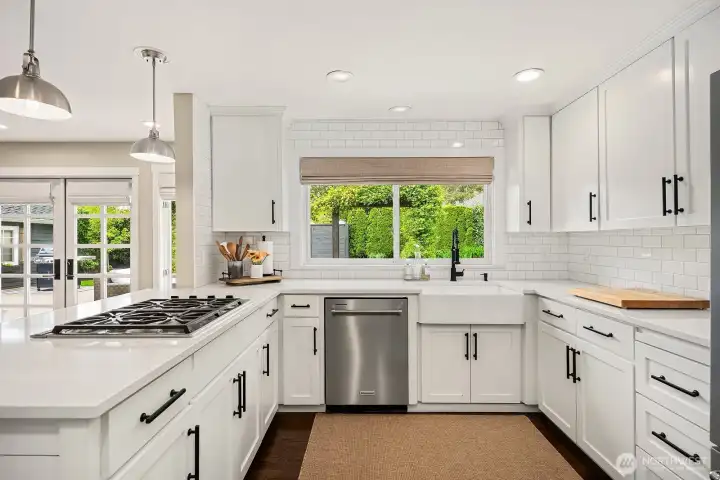 Every detail shines in this chef-ready kitchen, from the professional-grade range and new stainless appliances to the deep sink framed by a garden window — ample counter space and storage complete the picture.