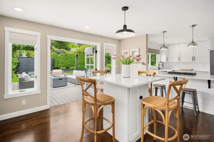 The bright eating nook flows seamlessly from the kitchen through elegant French doors to the brand-new Trex deck beyond, making indoor-outdoor entertaining effortless year-round.