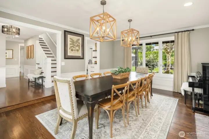 The elegant formal dining room impresses with classic wainscoting, a statement chandelier, and rich hardwood floors — a sophisticated space perfectly sized for hosting dinner parties and holiday gatherings alike.