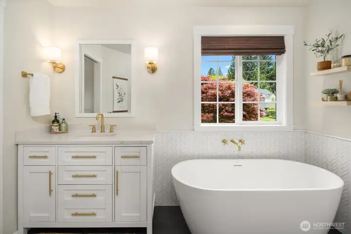 The luxurious 5-piece primary bath impresses with a freestanding soaking tub, dual vanity with elegant fixtures, and a sun-drenched window — a spa-like escape that elevates everyday living.