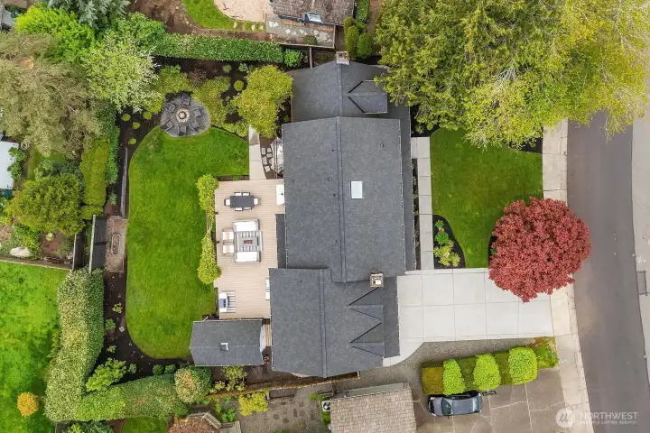 This aerial view showcases the home's brand-new roof, generous lot, and beautifully landscaped grounds, while highlighting the private fully fenced backyard, Trex deck, and the convenient outbuilding — all nestled in the heart of the coveted Timberline neighborhood.