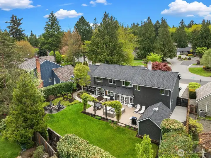 This sweeping aerial view captures the full scope of this exceptional property — from the brand-new roof and freshly repaved driveway to the expansive backyard, Trex deck, fire pit, and lush mature landscaping that make this Timberline home truly one of a kind.