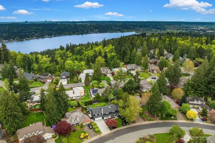 A breathtaking aerial perspective reveals the home's prime Timberline neighborhood setting, with glimpses of the nearby lake, tree-lined streets, and the exceptional natural beauty that makes this community one of the most sought-after in the Lake Washington School District.