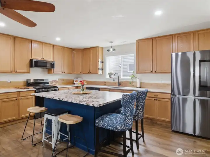 Designed with both storage and workspace in mind, the kitchen features generous cabinetry, a large island, and an efficient layout for daily living. Designed with both storage and workspace in mind, the kitchen features generous cabinetry, a large island, and an efficient layout for daily living.