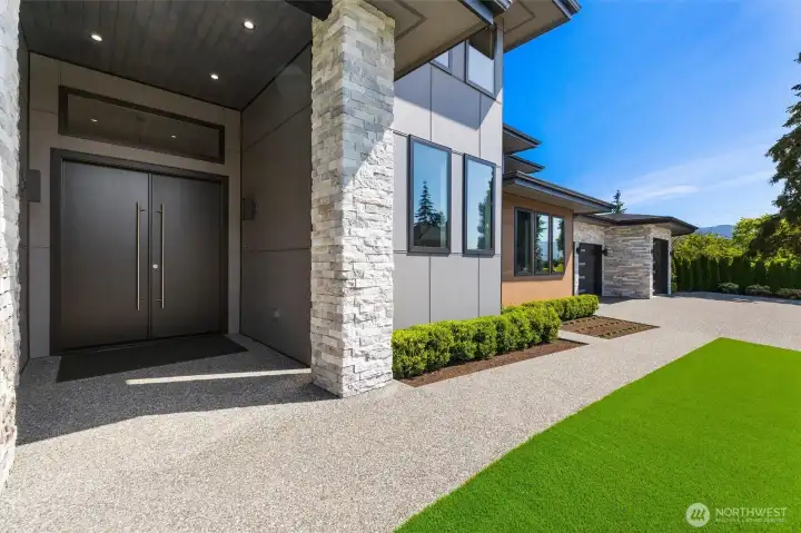 Spacious exterior front entry with 12-foot ceilings and accent lighting, leading to 8-foot tall double door entry.