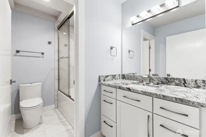 Separate granite vanity and shower/tub/toilet room. Porcelain tiled tub/shower  surround.