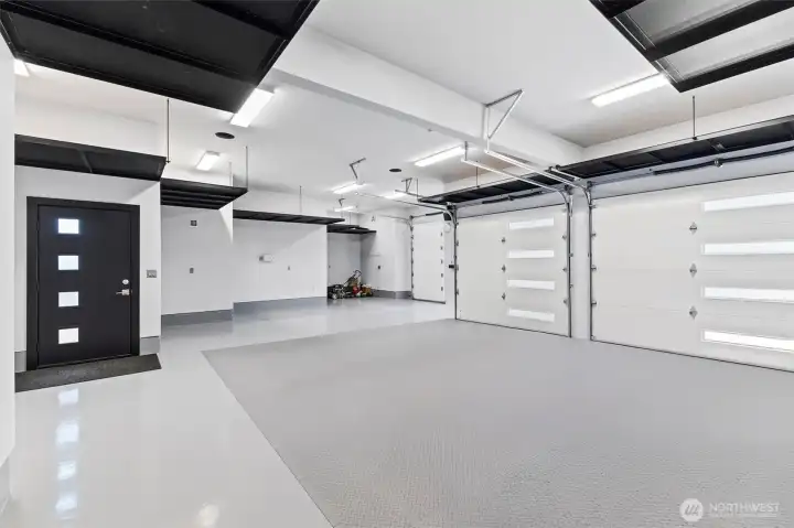 3 car garage plus additional floor storage with epoxy floor finish. 11-foot ceilings  ? Suspended powder coated metal hanging 4-foot deep storage shelving