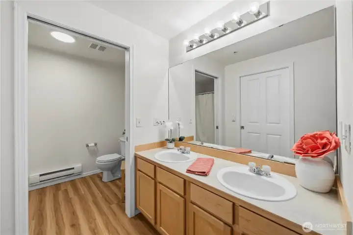 Primary bath hosts double sinks, two pocket doors for Walk-in closet and tub/shower area