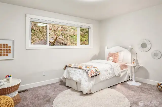 This upstairs guest room offers an oversized picture window with custom room-darkening shade.