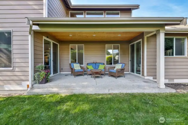 Expansive fenced backyard with with covered patio and firepit.
