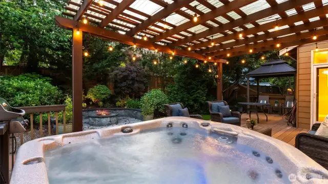 A hot tub on the deck, steaming under string lights and a crackling fire, invites slow soaks, chill tunes, and golden hour views!