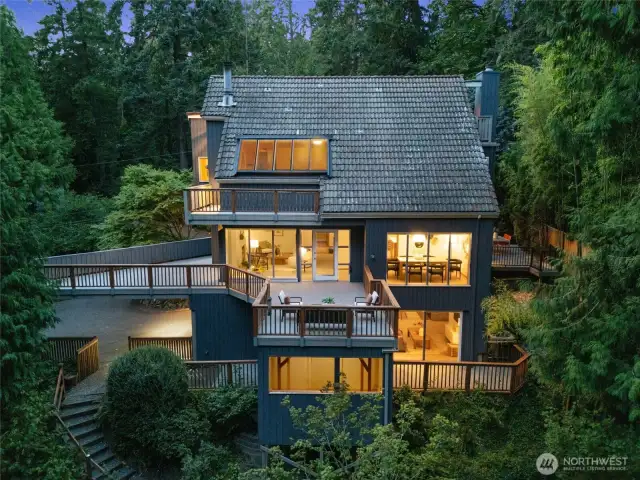 Perched in the treetops, wrapped in windows, and warm with charm— this home is your private, light-filled retreat!