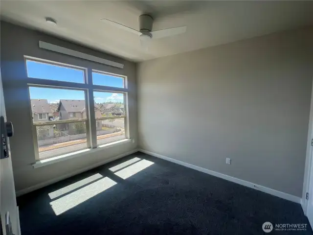 1st bedroom with ceiling fan and large windows