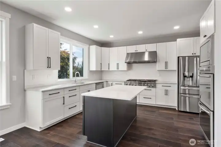 Slab quartz countertops, 3' x 6' island, subway tile backsplash and Pecan flooring make for a stylish kitchen!
