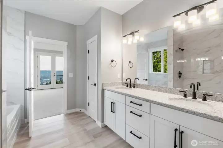 5-piece primary bathrooms with Moen Gibson bath fixtures, floor to ceiling ceramic tile shower wih double shower head, soaking tub, undercount double sinks, quartz counters, and ceramic tile floors.