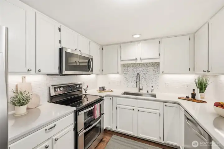 Updated kitchen with quartz countertops, double-oven range, subway tile backsplash & engineered hardwood floors. (Virtually Staged)