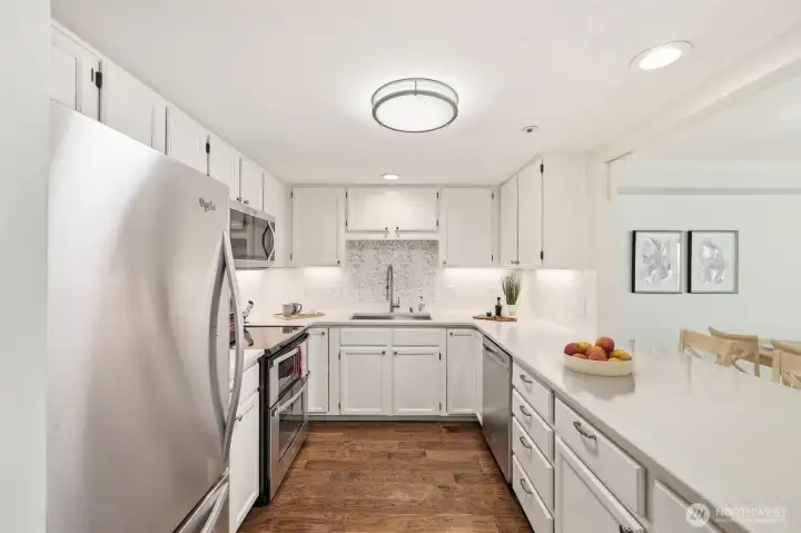 Updated kitchen with quartz countertops & stainless appliances. (Virtually Staged)