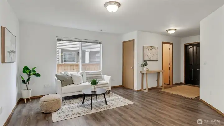A refined living space bathed in natural light, thoughtfully positioned off the dining room with a convenient nearby coat closet for guests.