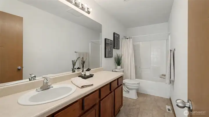 Generously sized with elegant finishes, this bathroom combines a large vanity with a relaxing tub for everyday convenience and luxury.