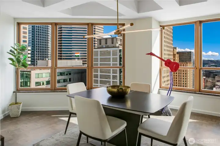 The dining room occupies a prominent corner of the penthouse, positioned to enjoy expansive outlooks across the city.