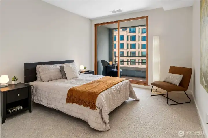 Large windows bring the surrounding skyline into the bedroom while maintaining calm above the streets below.