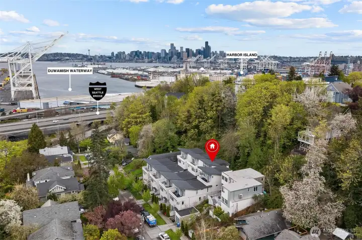 Aerial view facing northeast toward downtown Seattle skyline, Harbor Island, and the Duwamish Waterway, illustrating proximity to the West Seattle Bridge and major industrial waterfront corridor.