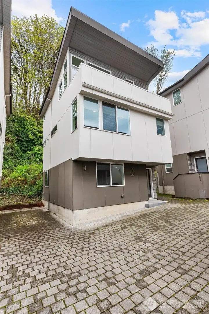 Front exterior of home featuring modern facade, flat rooflines, and dedicated off-street parking area.