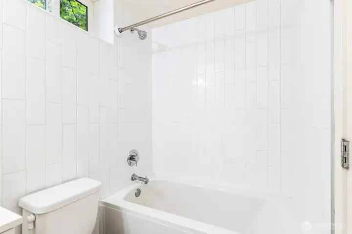 Lower-level full bathroom with tile surround shower/tub combination and updated fixtures.