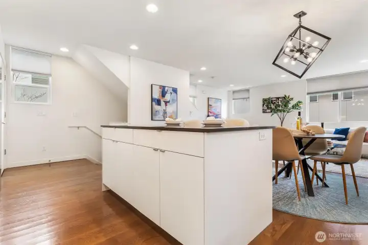 Kitchen and dining area with open layout, island storage, and modern lighting fixture.